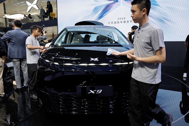&copy; Reuters. FILE PHOTO: Staff members clean an Xpeng X9 electric vehicle displayed at the Beijing International Automotive Exhibition, or Auto China 2024, in Beijing, China, April 25, 2024. REUTERS/Tingshu Wang/File Photo
