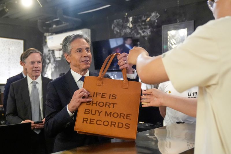 &copy; Reuters. U.S. Secretary of State Antony Blinken takes a bag after buying records during a visit to Li-Pi record store in Beijing, China, April 26, 2024.     Mark Schiefelbein/Pool via REUTERS