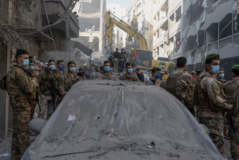 © Reuters. Civil defense members work as Lebanese army soldiers stand guard at the site of an Israeli strike in Beirut's Basta neighbourhood, amid the ongoing hostilities between Hezbollah and Israeli forces, Lebanon November 23, 2024. REUTERS/Adnan Abidi