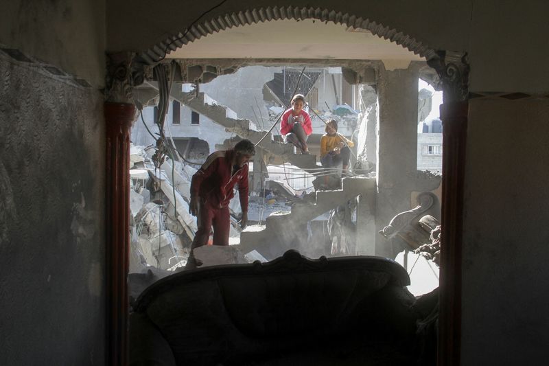 © Reuters. A Palestinian man inspects a house hit in an Israeli strike, amid the ongoing conflict between Israel and Hamas, in Gaza City November 21, 2024. REUTERS/Mahmoud Issa      