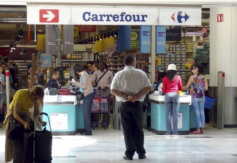 © Reuters. FILE PHOTO: Customers queue at cash registers in a Carrefour supermarket in Montreuil near Paris August 29, 2012. REUTERS/Charles Platiau/File Photo