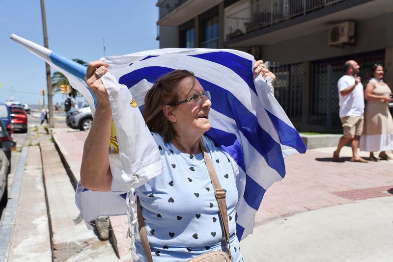 © Reuters. A woman holds a Uruguayan flag, during the Presidential election run-off, in Montevideo, Uruguay November 24, 2024. REUTERS/Martin Varela Umpierrez