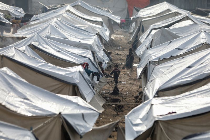 © Reuters. Displaced Palestinian children stand near tents following rainfall, amid the Israel-Hamas conflict, in Gaza City November 24, 2024. REUTERS/Dawoud Abu Alkas