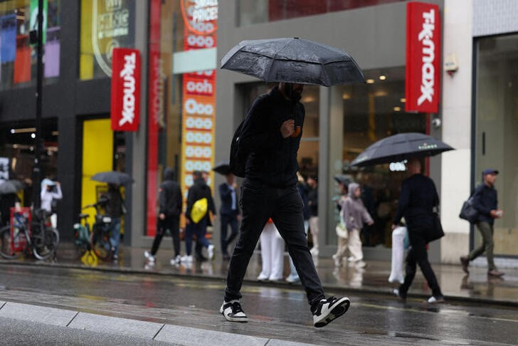 &copy; Reuters. FILE  PHOTO: Shopper holds an umbrella while crossing the road on Oxford Street in London, Britain, July 9, 2024. REUTERS/Hollie Adams/File Photo