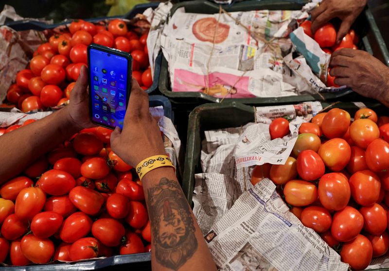 © Reuters. FILE PHOTO: Tomatoes covered with newspapers are seen in baskets at a vegetable wholesale market in Navi Mumbai, India August 4, 2023. REUTERS/Francis Mascarenhas/File Photo