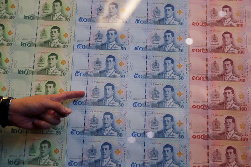 © Reuters. FILE PHOTO: Central bank governor Veerathai Santiprabhob points to new baht bank notes featuring Thailand's King Maha Vajiralongkorn during a news conference at Bank of Thailand headquarters in Bangkok, Thailand March 8, 2018. REUTERS/Jorge Silva/File Photo