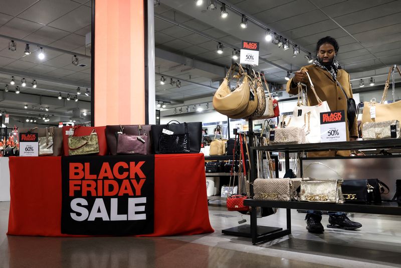 © Reuters. FILE PHOTO: A person picks up a purse in Macy's department store during a Black Friday sale, in New York City, New York U.S., November 20, 2024. REUTERS/Kent J Edwards/File Photo