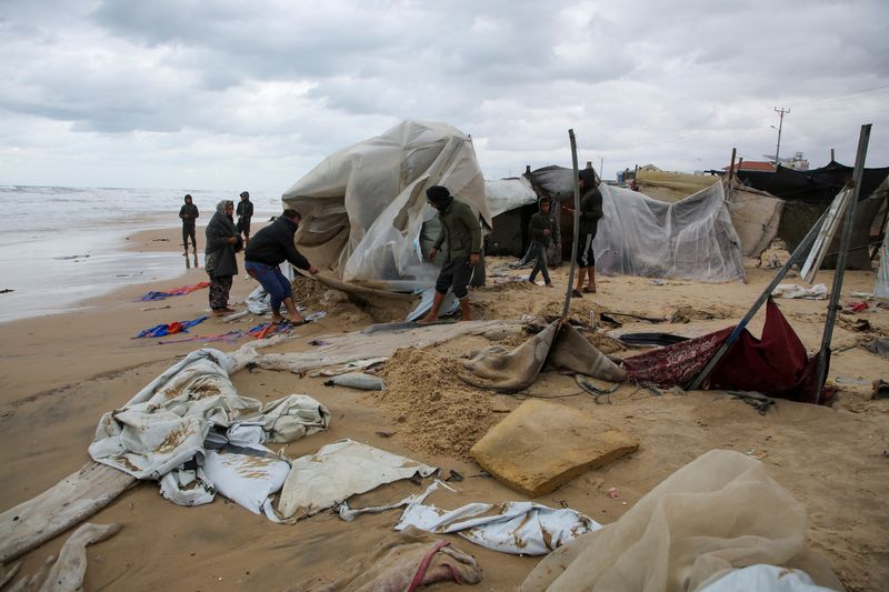 © Reuters. Displaced Palestinians inspect a damaged tent following rising sea levels and heavy rainfall, amid the ongoing conflict between Israel and Hamas, in Khan Younis in the southern Gaza Strip, November 25, 2024. REUTERS/Hatem Khaled