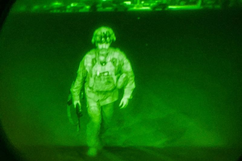 © Reuters. FILE PHOTO: U.S. Army Major General Chris Donahue, commander of the 82nd Airborne Division, steps on board a C-17 transport plane as the last U.S. service member to leave Hamid Karzai International Airport in Kabul, Afghanistan August 30, 2021 in a photograph taken using night vision optics.  XVIII Airborne Corps/Handout via REUTERS. 