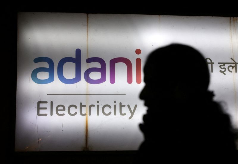 &copy; Reuters. FILE PHOTO: A woman walks past the Adani Electricity corporate office building in Mumbai, India, February 6, 2023. REUTERS/Francis Mascarenhas/File Photo