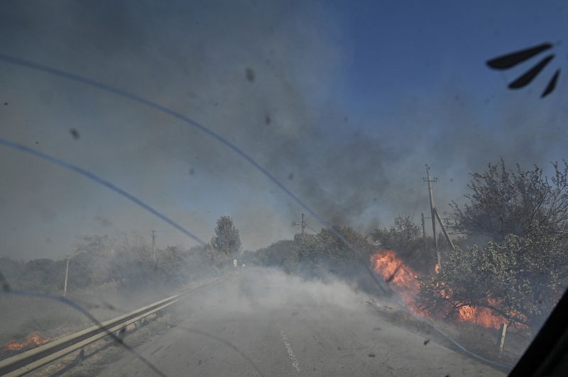 &copy; Reuters. Policial dirige veículo em meio à fumaça de explosões durante retirada de civis dos arredores da cidade de Kurakhove, na região ucraniana de Donetskn16/09/2024 REUTERS/Stringer