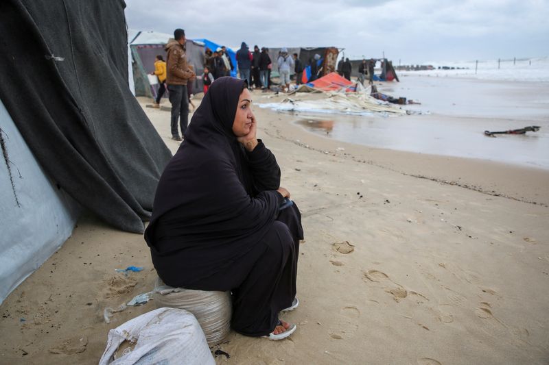 &copy; Reuters. Una donna palestinese sfollata siede fuori da una tenda allagata in seguito all'innalzamento del livello del mare e alle forti piogge, nel contesto del conflitto in corso tra Israele e Hamas, a Khan Younis, nel sud della Striscia di Gaza, il 25 novembre 2