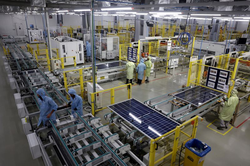 © Reuters. FILE PHOTO: Workers assemble Photovoltaic Modules at the plant of Adani Green Energy Ltd (AGEL) in Mundra, India, April 11, 2024. REUTERS/Amit Dave/File Photo