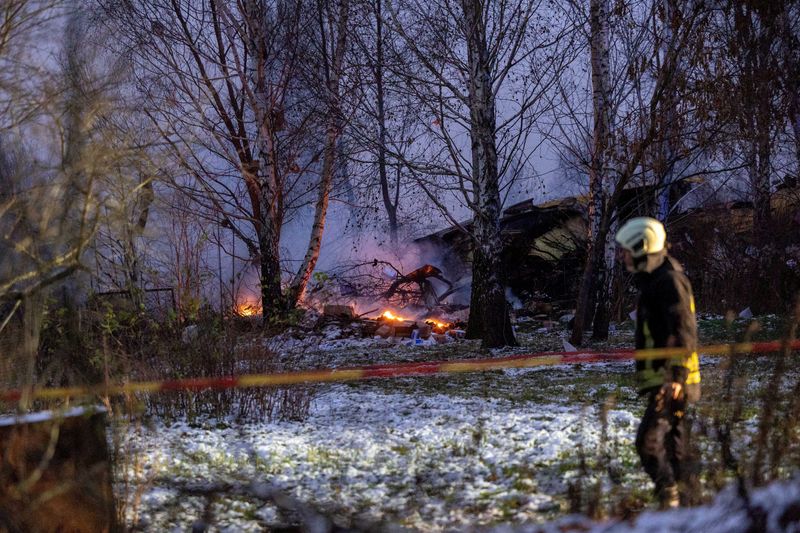 &copy; Reuters. FILE PHOTO: Rescuer walks past DHL cargo plane wreckage, at the crash site near Vilnius International Airport, Lithuania November 25, 2024. Lukas Balandis/BNS via REUTERS/File Photo