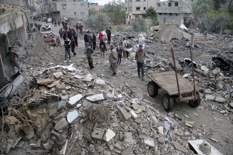 &copy; Reuters. Palestinesi si riuniscono sul luogo di un attacco israeliano a una casa, nel corso del conflitto in corso tra Israele e Hamas a Gaza, il 26 novembre 2024. REUTERS/Mahmoud Issa