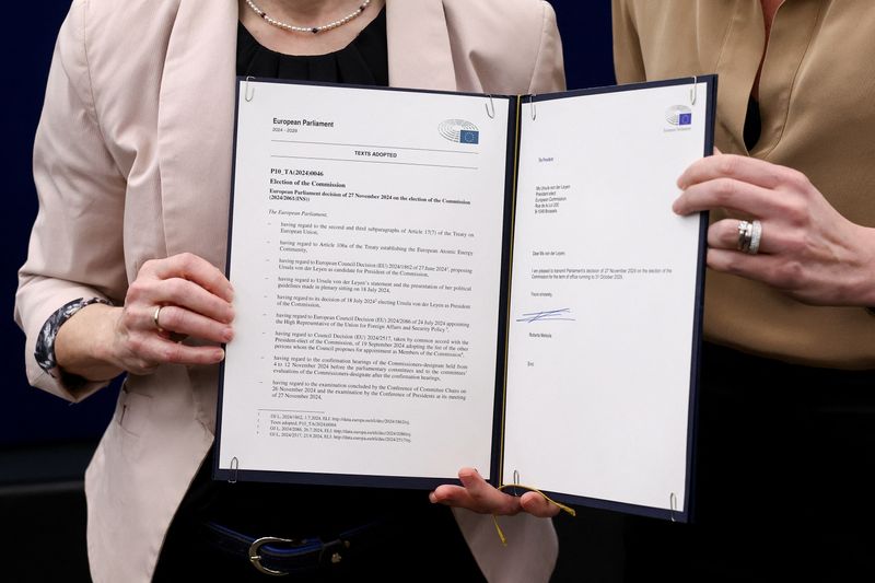 &copy; Reuters. La Presidente della Commissione europea Ursula von der Leyen e la Presidente del Parlamento europeo Roberta Metsola posano per una foto con un documento che conferma l'approvazione della nuova Commissione europea da parte del Parlamento dopo una votazione