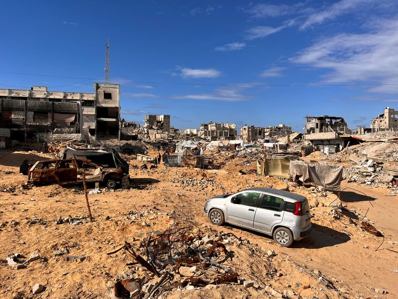 &copy; Reuters. Palestinians walk through a damaged site amid the Israel-Hamas conflict, in Khan Younis, southern Gaza Strip November 27, 2024. REUTERS/Hussam Al-Masri