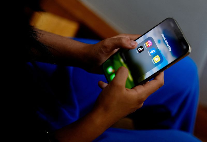 © Reuters. A high school student poses with her mobile showing her social media applications in Melbourne, Australia, November 28, 2024. REUTERS/Asanka Brendon Ratnayake/File Photo