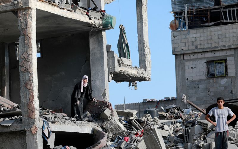 © Reuters. Palestinians stand amid the destruction after Israeli forces withdrew from a part of Nuseirat, following a ground operation amid the ongoing conflict between Israel and Hamas, in Nuseirat, central Gaza Strip, November 29, 2024. REUTERS/Abd Elhkeem Khaled