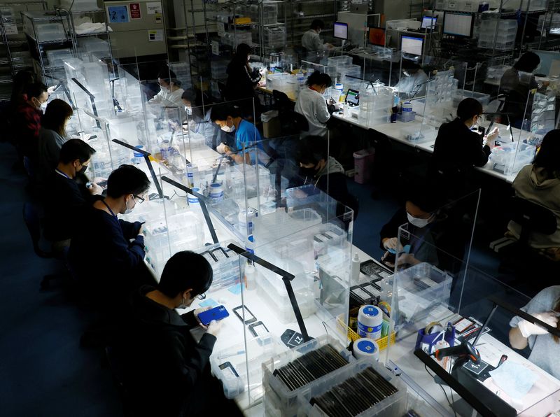 © Reuters. FILE PHOTO: Workers clean used iPhones at an operations centre of Belong Inc, a unit of trading house Itochu Corp that sells used phones and tablets online, in Zama, Kanagawa Prefecture, Japan October 27, 2022. REUTERS/Kim Kyung-Hoon/File Photo