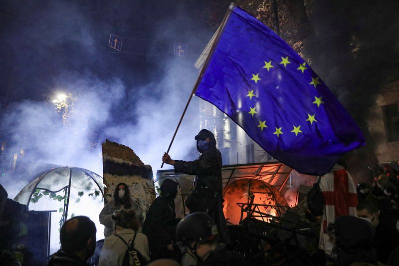 © Reuters. A demonstrator waves a European Union flag during a protest against the new government's decision to suspend the European Union accession talks and refuse budgetary grants until 2028, in Tbilisi, Georgia November 30, 2024. REUTERS/Irakli Gedenidze    