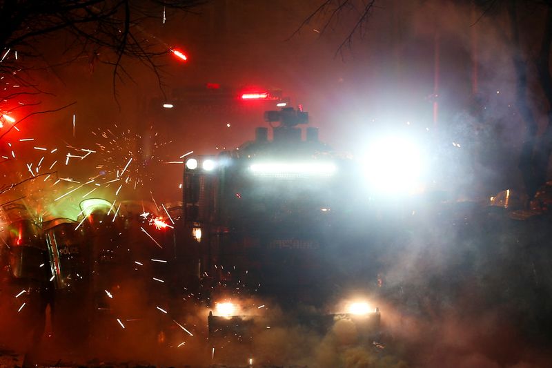 © Reuters. Fireworks explode in front of law enforcement officers during a protest, Tbilisi, December 2, 2024. REUTERS/Irakli Gedenidze