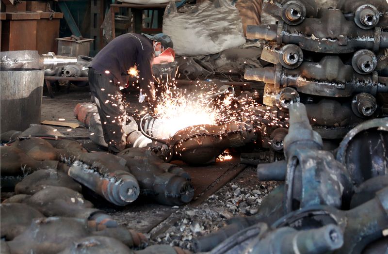 © Reuters. FILE PHOTO: A worker welds automobile parts at a workshop manufacturing automobile accessories in Huaibei, Anhui province, China June 28, 2019. Picture taken June 28, 2019. REUTERS/Stringer/File Photo