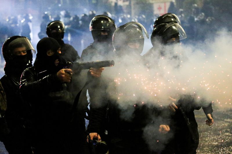 &copy; Reuters. A law enforcement officer fires a tear gas canister as fireworks explode during a protest against the new government's decision to suspend the European Union accession talks and refuse budgetary grants until 2028, in Tbilisi, Georgia December 2, 2024. REU