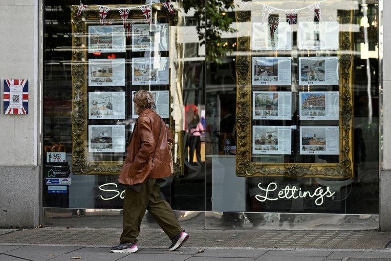 &copy; Reuters. FILE PHOTO: A woman looks at property notices displayed as she walks past a real estate agency in Kensington, in London, Britain, September 17, 2024. REUTERS/Jaimi Joy/File Photo