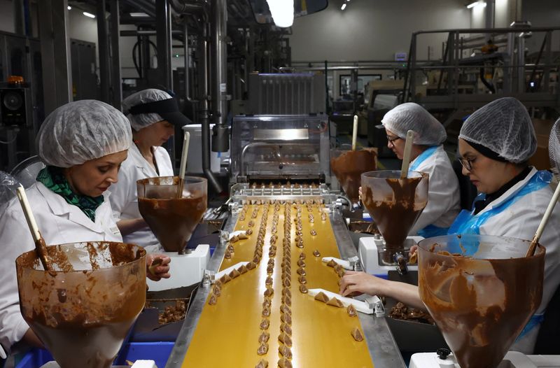 &copy; Reuters. FILE PHOTO: Workers work during the manufacturing process of chocolate pralines at Belgian chocolate maker Neuhaus in Vlezenbeek, near Brussels, Belgium May 15, 2024. REUTERS/Yves Herman/File Photo