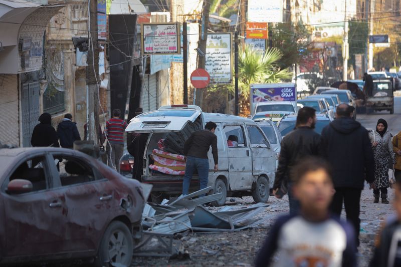 &copy; Reuters. People walk past a damaged site in Aleppo, after the Syrian army said that dozens of its soldiers had been killed in a major attack by rebels who swept into the city, in Syria November 30, 2024. REUTERS/Mahmoud Hassano