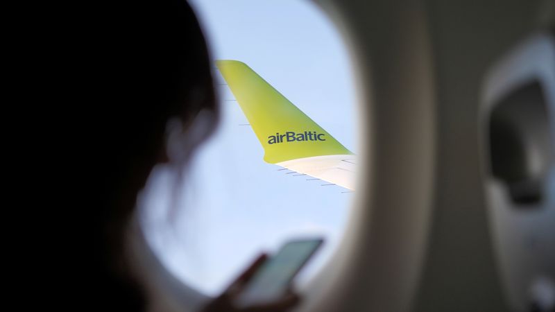 &copy; Reuters. FILE PHOTO: Wing of an AirBaltic Airbus A220 is seen as a passenger holds a phone during a flight over Latvia, October 25, 2020.  Picture taken October 25, 2020. REUTERS/Janis Laizans/File Photo