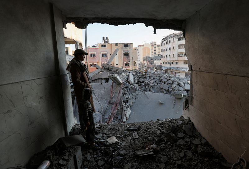 &copy; Reuters. A Palestinian man and child look on from the site of an Israeli strike on a house, amid the Israel-Hamas conflict, in Nuseirat in the central Gaza Strip December 1, 2024. REUTERS/Ramadan Abed/File Photo