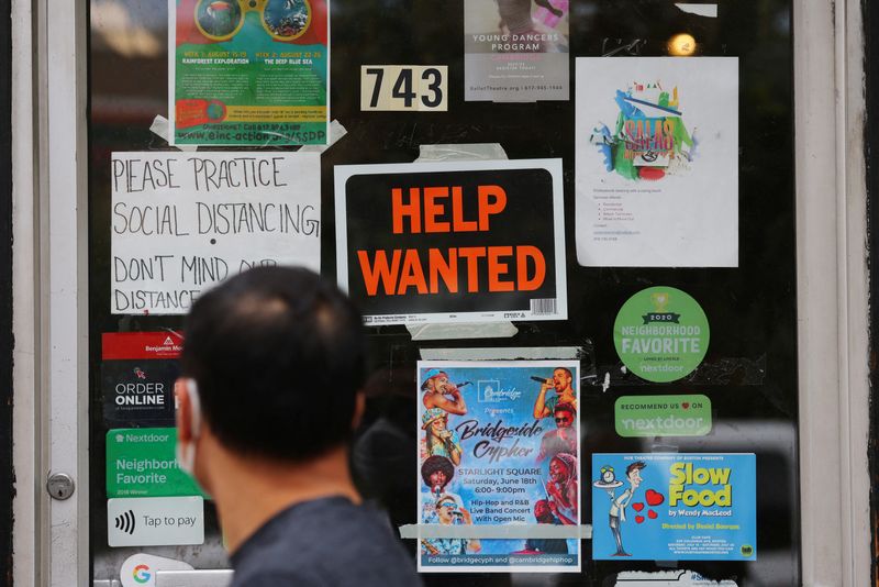 &copy; Reuters. Un pedone passa davanti a un cartello “Help Wanted” sulla porta di un negozio di ferramenta a Cambridge, Massachusetts, Stati Uniti, 8 luglio 2022. REUTERS/Brian Snyder