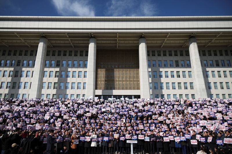 ©Reuters. Manifestantes seguram cartazes enquanto pessoas e legisladores participam de um comício para condenar as declarações surpresa de lei marcial do presidente sul-coreano na noite passada e exigir sua renúncia na Assembleia Nacional em Seul, Coreia do Sul, em 4 de dezembro de 2024. REUTERS/Kim Hong-Ji