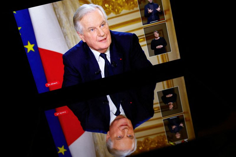 © Reuters. FILE PHOTO: A screen displays French Prime Minister Michel Barnier as he talks during an interview on French television at the Hotel Matignon in Paris, France, December 3, 2024. REUTERS/Stephanie Lecocq/File Photo