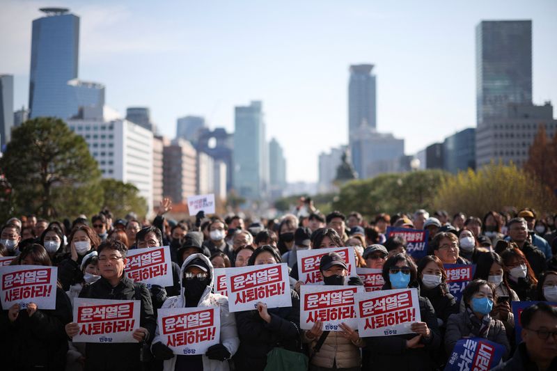 © Reuters. Protesters hold up signs that read 