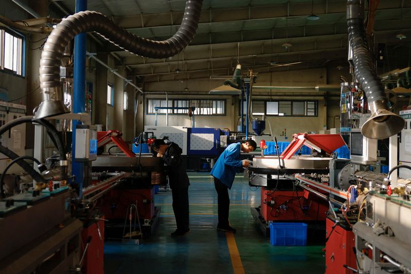 © Reuters. FILE PHOTO: Workers monitor the production line of drip tape fittings at a factory of DAYU Water Group Co, in Jiuquan, during an organised media tour in Gansu province, China October 18, 2024. REUTERS/Tingshu Wang/File Photo