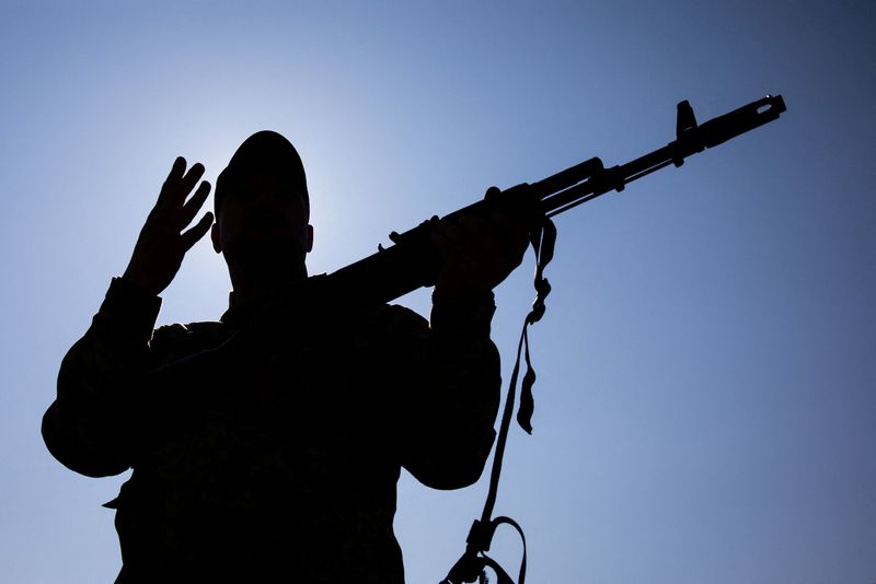 © Reuters. Silhouette of a Kyiv territorial defence member with a Kalashnikov rifle in his hands, March 25, 2022. REUTERS/Mikhail Palinchak/File Photo