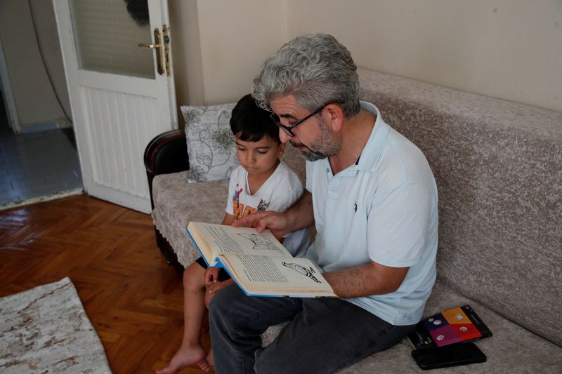 &copy; Reuters. FILE PHOTO: INevzat Yesilbagdan, reads a book in Kurdish, an anthology of children's stories, to his seven-year-old son Muhammed Mesrur at their home in Istanbul, Turkey, September 4, 2024. REUTERS/Dilara Senkaya/File Photo