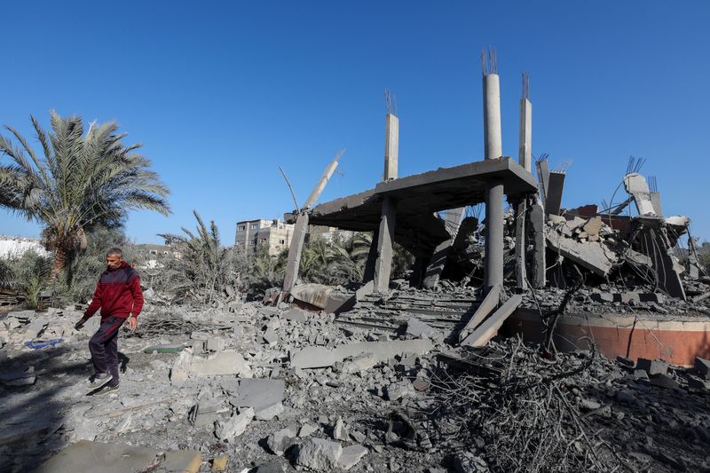 &copy; Reuters. A Palestinian man walks at the site of an Israeli strike on a house, amid the Israel-Hamas conflict, in Deir Al-Balah in the central Gaza Strip December 4, 2024. REUTERS/Ramadan Abed