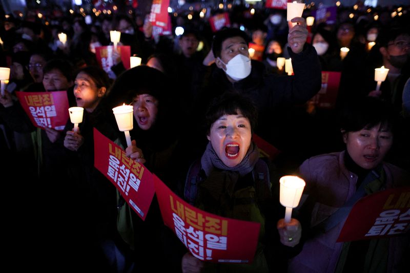 © Reuters. People attend a candlelight vigil condemning South Korean President Yoon Suk Yeol's surprise declaration of martial law last night, which was reversed hours later, and to call for his resignation, in Seoul, South Korea, December 4, 2024. REUTERS/Kim Kyung-Hoon  