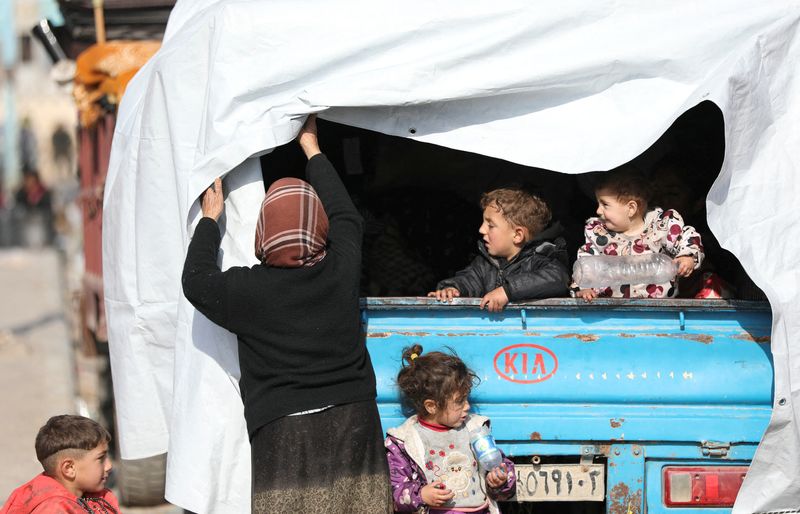 © Reuters. Displaced children who fled the Aleppo countryside, stand at the back of a truck in Tabqa, Syria December 4, 2024. REUTERS/Orhan Qereman 