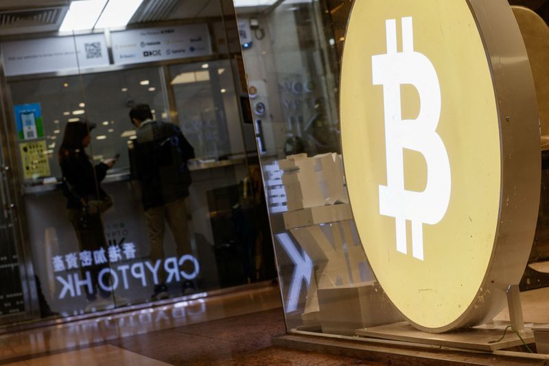 &copy; Reuters. FILE PHOTO: Customers stand at a cryptocurrency exchange store after Bitcoin soars above $100,000, in Hong Kong, China December 5, 2024. REUTERS/Tyrone Siu/File Photo