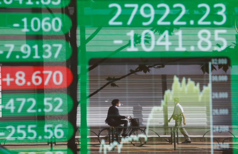 &copy; Reuters. FILE PHOTO: People are reflected on an electric board showing Nikkei index and its graph outside a brokerage at a business district in Tokyo, Japan, June 21, 2021.   REUTERS/Kim Kyung-Hoon/File Photo