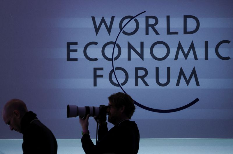 © Reuters. FILE PHOTO: A person takes a photo next to a logo during the 54th annual meeting of the World Economic Forum, in Davos, Switzerland, January 19, 2024. REUTERS/Denis Balibouse/File Photo