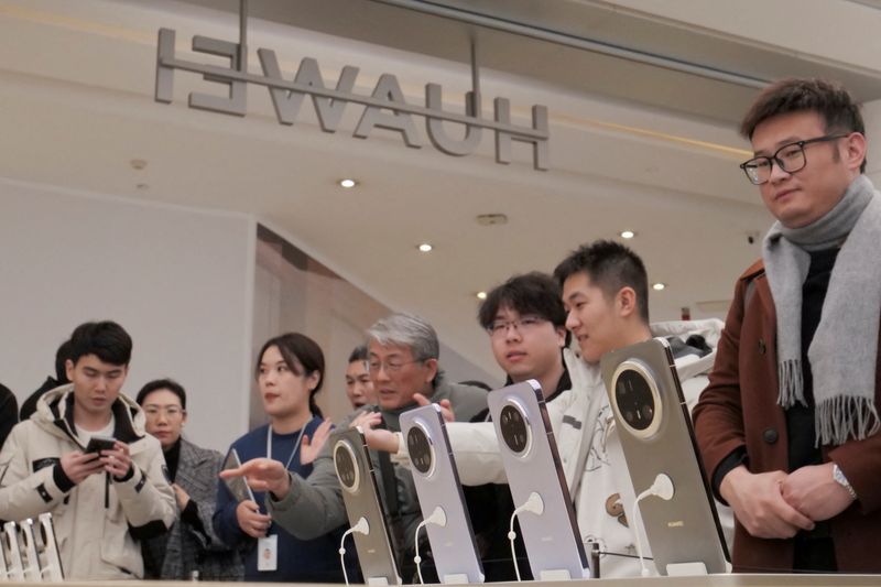 © Reuters. FILE PHOTO: Visitors look at Huawei's newly unveiled Mate 70 smartphone series at a flagship store in Beijing, China November 26, 2024.  REUTERS/Xiaoyu Yin/File Photo