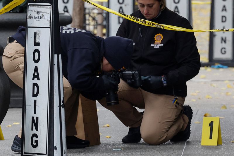 &copy; Reuters. FILE PHOTO: A member of the NYPD Crime Scene Unit takes a picture of a shell casing found at the scene where the CEO of UnitedHealthcare Brian Thompson was reportedly shot and killed in Midtown Manhattan, in New York City, U.S., December 4, 2024. REUTERS/