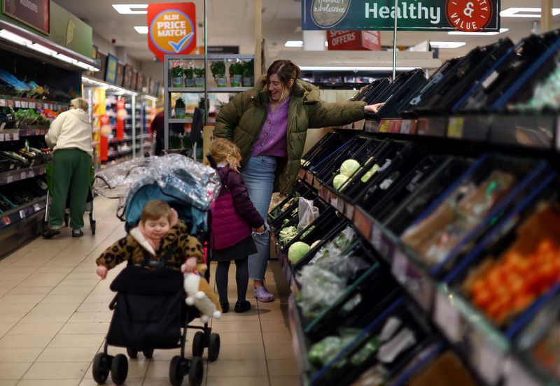 &copy; Reuters. FILE PHOTO: A woman buys groceries with her children from a store in Clitheroe, East Lancashire, Britain, March 1, 2023. REUTERS/Hannah McKay/File Photo