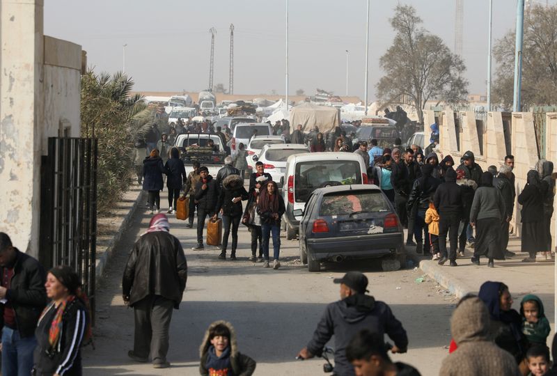 &copy; Reuters. Sfollati fuggiti dalla campagna di Aleppo camminano davanti a delle auto a Tabqa, Siria, 4 dicembre 2024. Foto REUTERS/Orhan Qereman